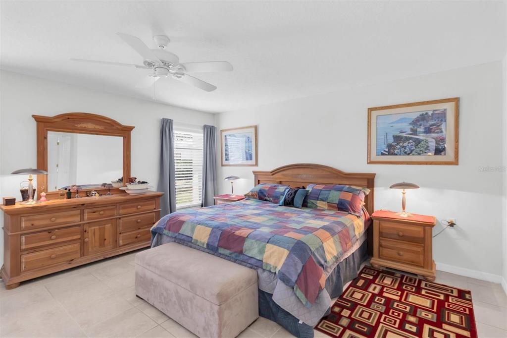 9052 Arundle Place New Port Richey, FL 34655 - Photo 14 of 57 a bedroom with a bed and dresser with mirror