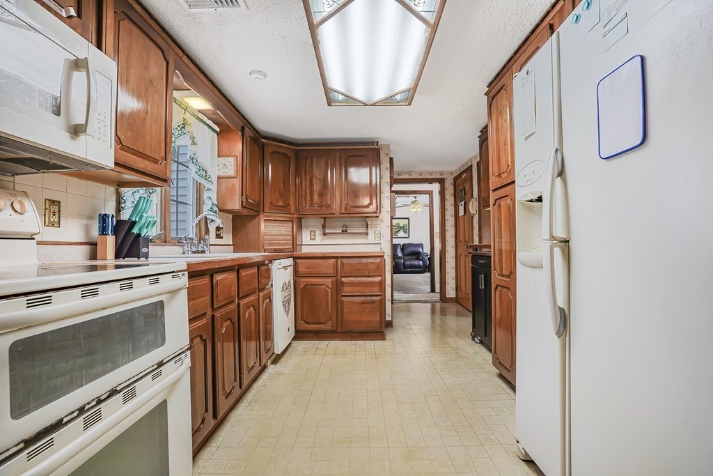 935 Almy Road Somerset, MA 02726 - Photo 15 of 37 a kitchen with stainless steel appliances granite countertop a stove a sink and a refrigerator