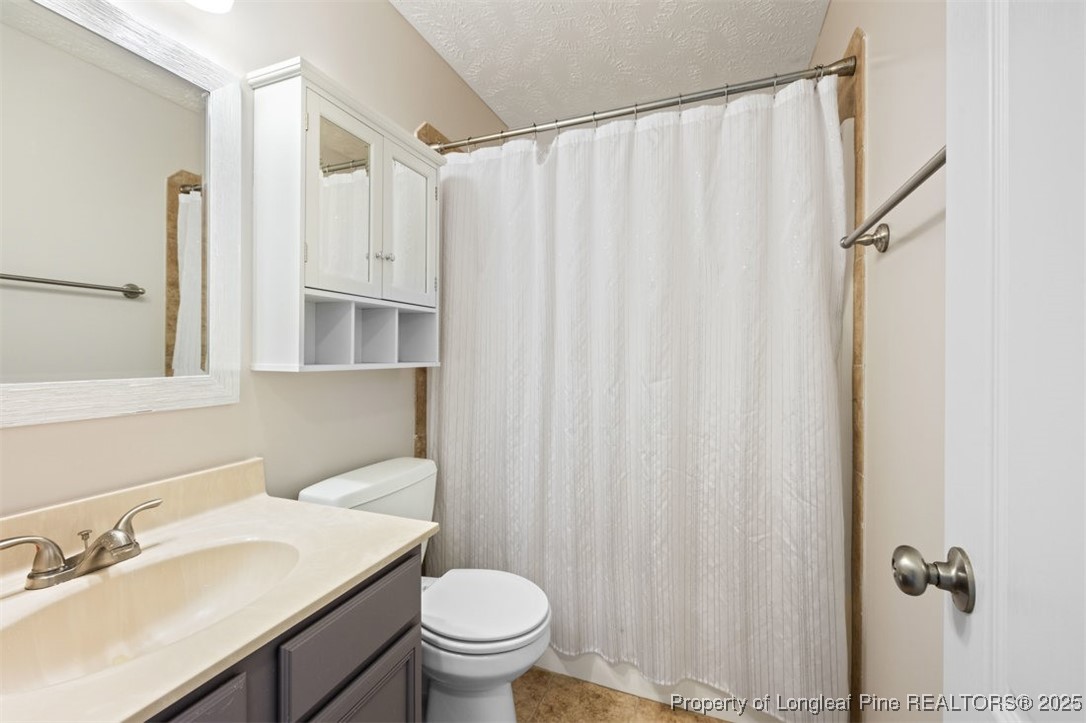 161 Bayleaf Drive Raeford, NC 28376 - Photo 27 of 33 a bathroom with a sink a toilet and shower curtain