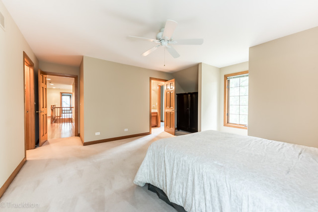 3700 Glendenning Road Downers Grove, IL 60515 - Photo 18 of 25 a spacious bedroom with a large bed and a chandelier