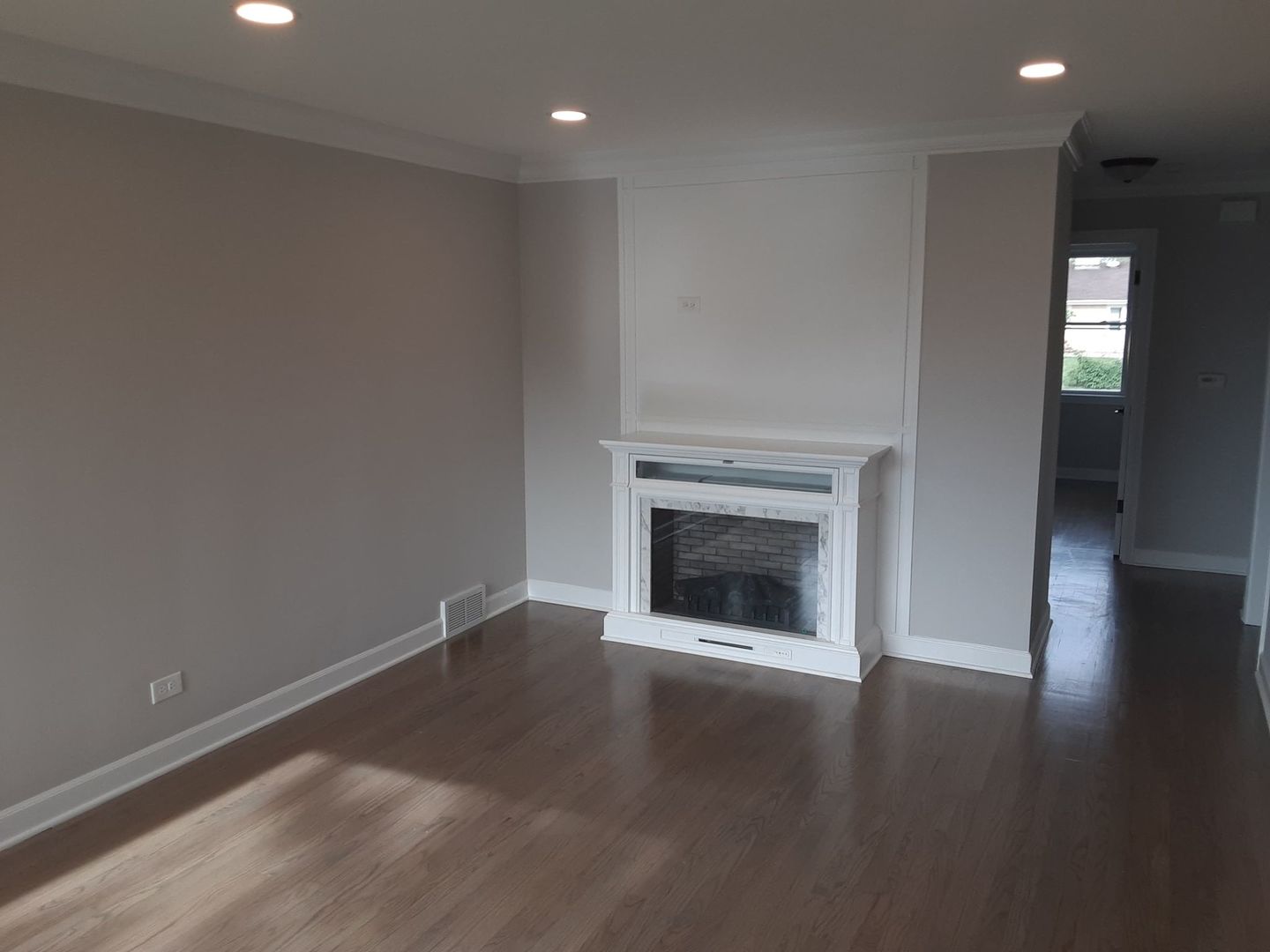 1417 Lee Boulevard Berkeley, IL 60163 - Photo 3 of 24 a view of an empty room with wooden floor fireplace and a window