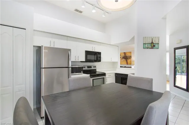 a kitchen with stainless steel appliances granite countertop a refrigerator a stove a microwave oven a sink with island and chairs