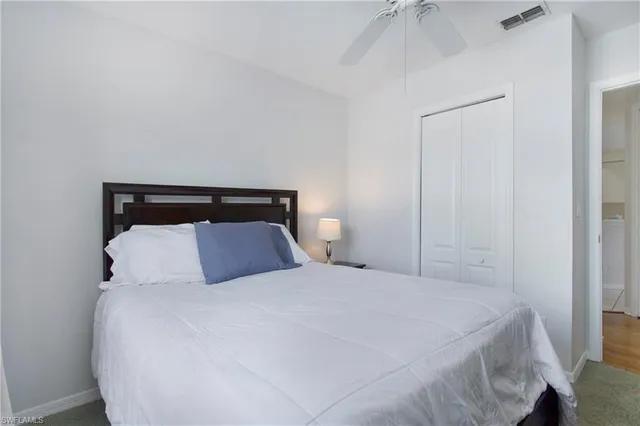 a bedroom with a large bed and a chandelier fan