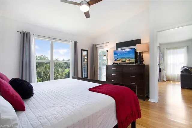 a bedroom with a bed dresser and a large window