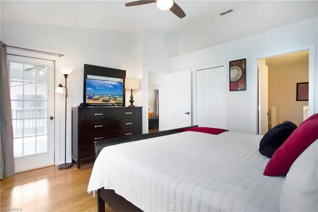 a bedroom with a bed and a flat tv screen on dresser