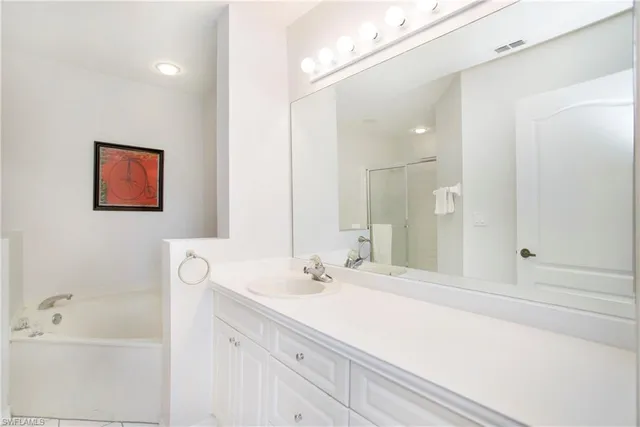 a bathroom with a double vanity sink mirror and bathtub