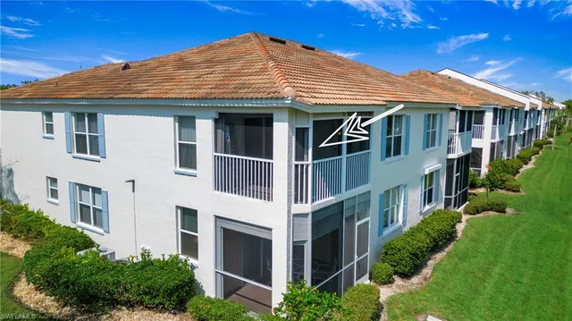 a view of a white house with large windows and a yard