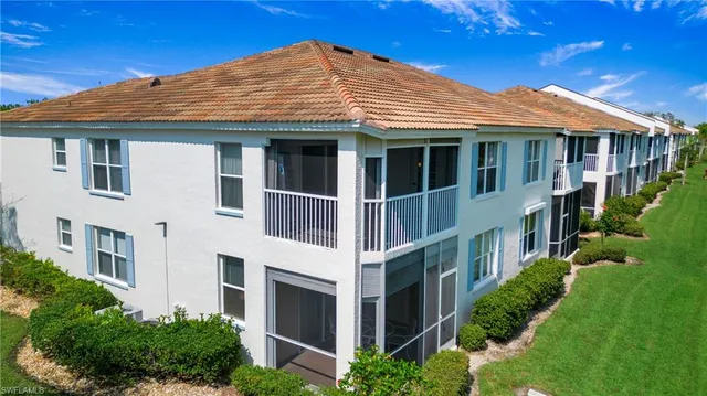 a view of a white house with a yard and potted plants