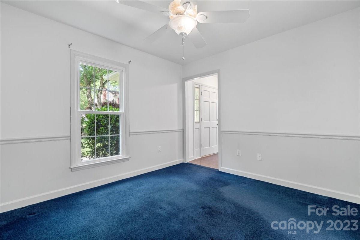 12112 Painted Tree Road Charlotte, NC 28226 - Photo 17 of 41 an empty room with wooden floor chandelier fan and windows