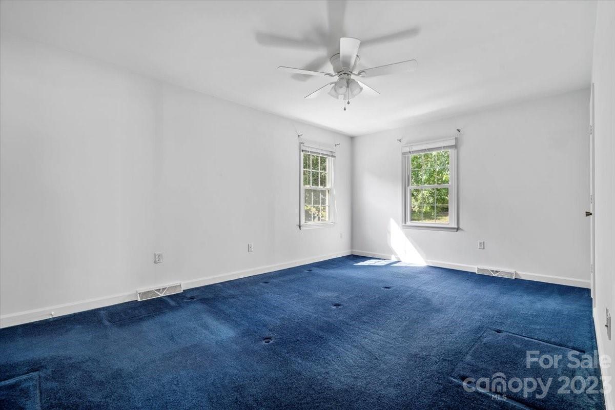 12112 Painted Tree Road Charlotte, NC 28226 - Photo 22 of 41 an empty room with wooden floor chandelier fan and windows