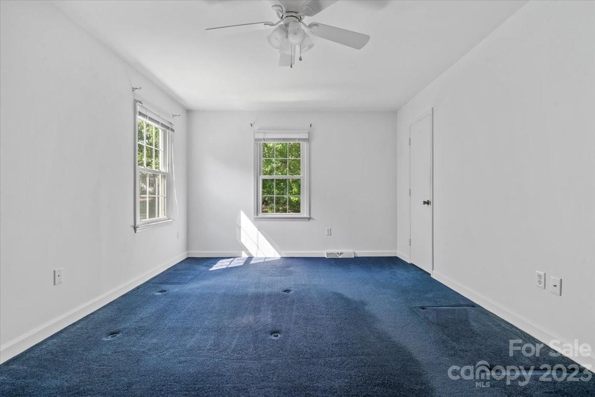 12112 Painted Tree Road Charlotte, NC 28226 - Photo 23 of 41 an empty room with windows and chandelier fan