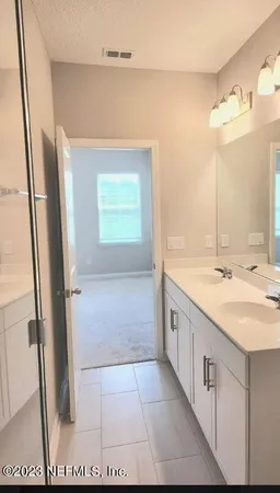 a bathroom with a granite countertop sink a mirror and a bathtub