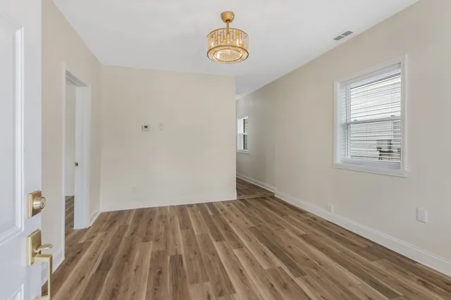 a view of a room with wooden floor ceiling fan and window