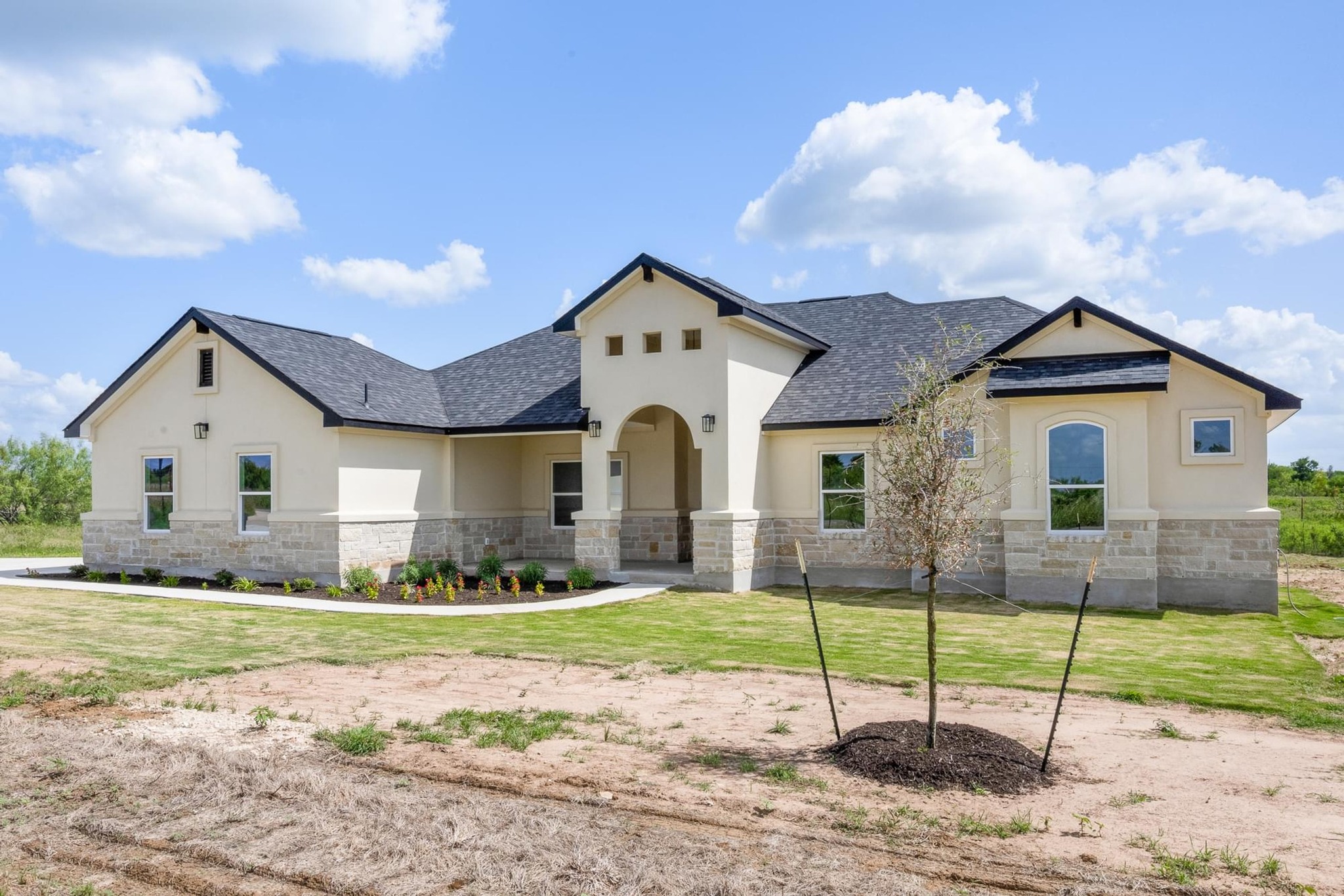 1136 County Road 484 Elgin, TX 78621 - Photo 2 of 37 View of front of home with stone siding, stucco siding, a front yard, and roof with shingles