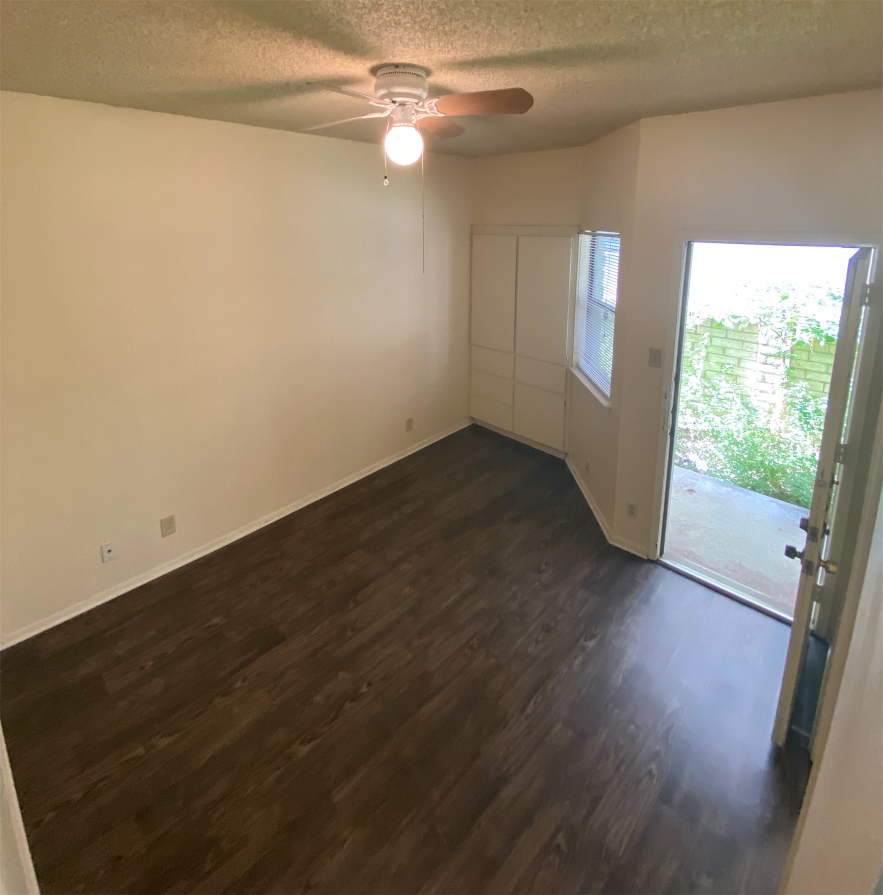 2604 Salado Street, Unit 102 Austin, TX 78705 - Photo 6 of 8 an empty room with wooden floor fan and windows