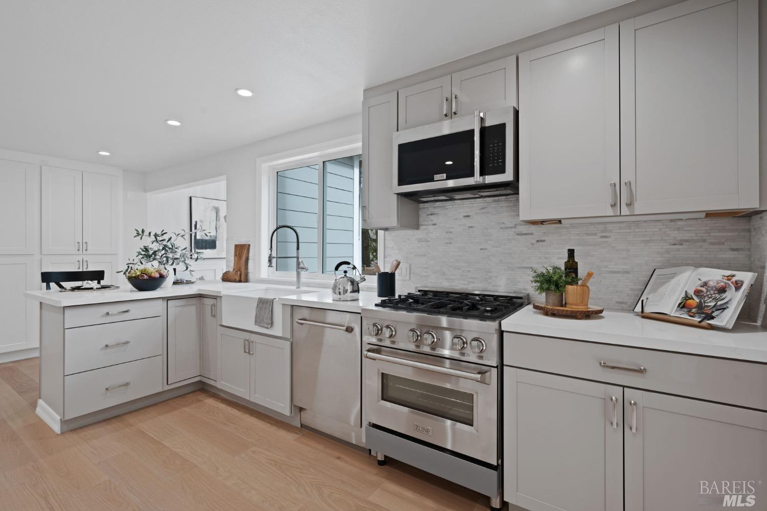 a kitchen with white cabinets and appliances