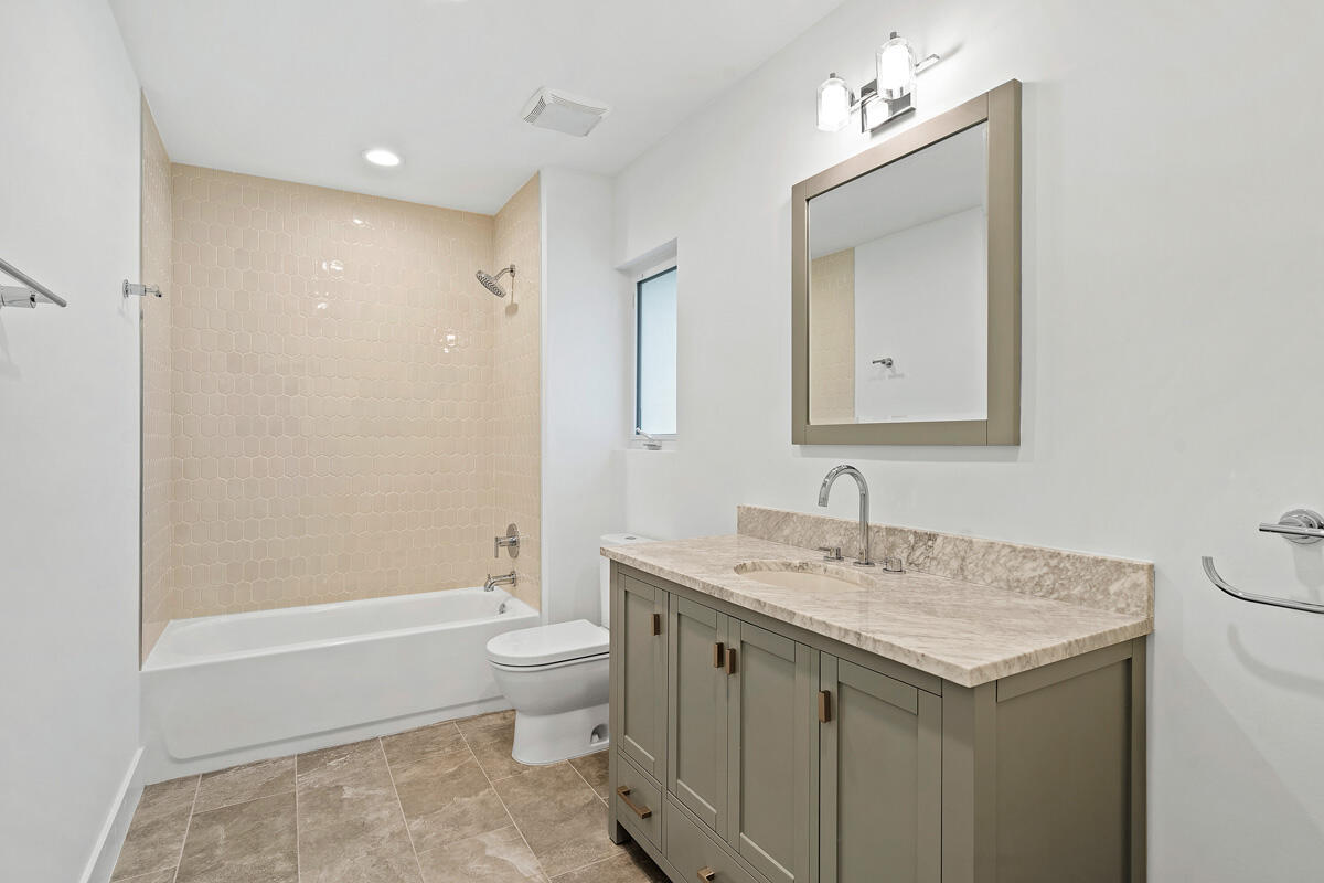 533 East Alexander Palm Road Boca Raton, FL 33432 - Photo 36 of 44 a bathroom with a granite countertop sink a toilet and a mirror