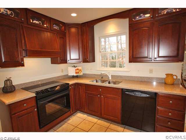 15203 Powell Grove Road Midlothian, VA 23112 - Photo 5 of 12 a kitchen with a sink a stove and cabinets