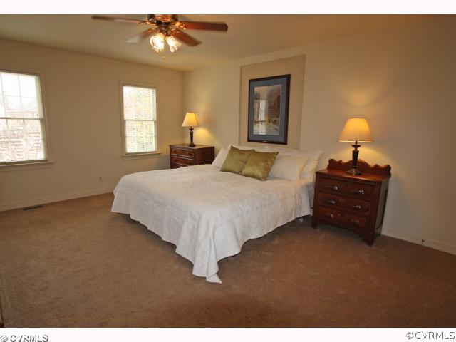 15203 Powell Grove Road Midlothian, VA 23112 - Photo 10 of 12 a bedroom with a bed and a lamp