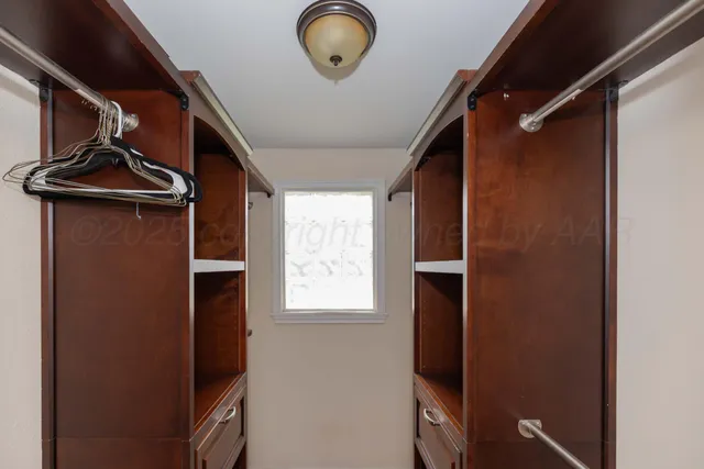 a view of walk in closet with clothes