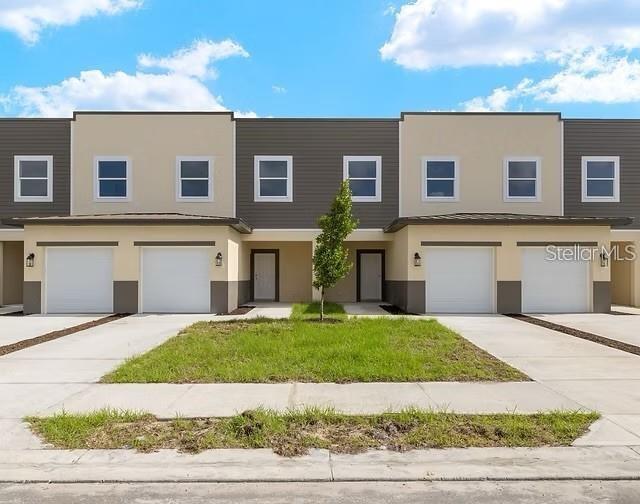 a front view of a house with a yard and garage