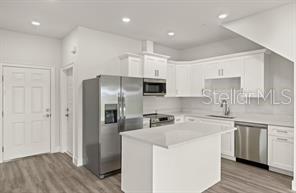 14989 Sunset Eve Loop Fort Myers, FL 33919 - Photo 4 of 9 a kitchen with cabinets and stainless steel appliances