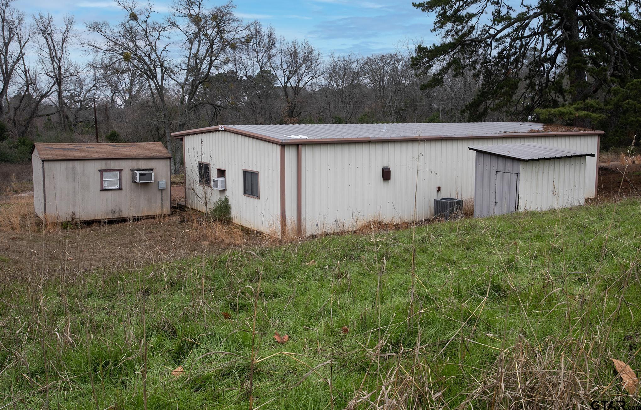 730 Humble Road New London, TX 75684 - Photo 24 of 24 a aerial view of a house with yard and trees in the background