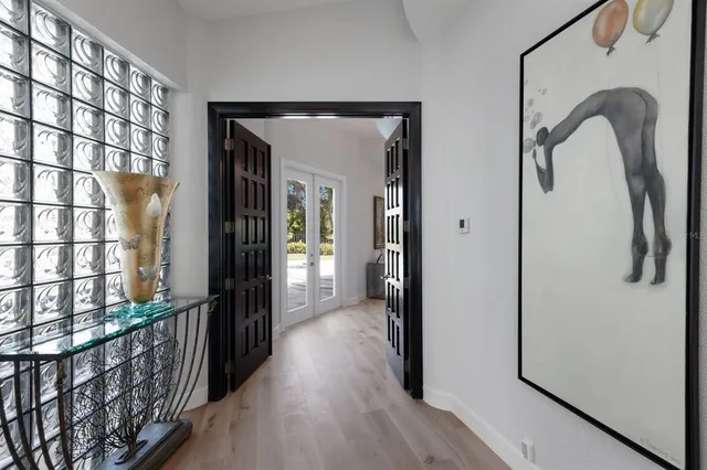 a bedroom with a bed a table and paintings on the wall