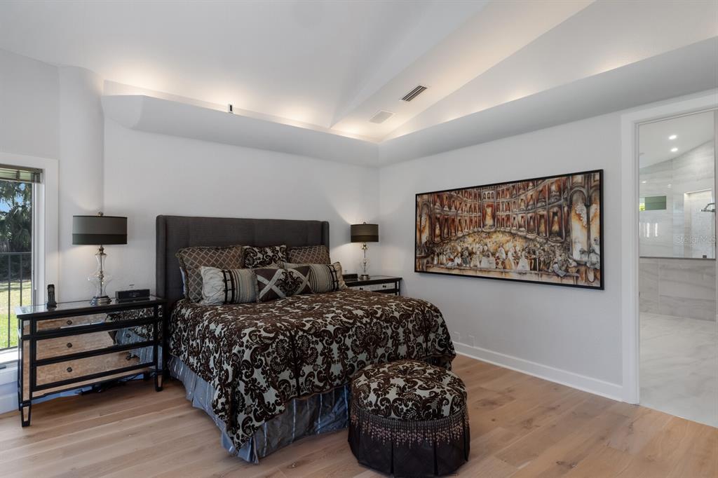 691 Eagle Watch Lane Osprey, FL 34229 - Photo 34 of 100 a bedroom with a bed and a painting on the wall