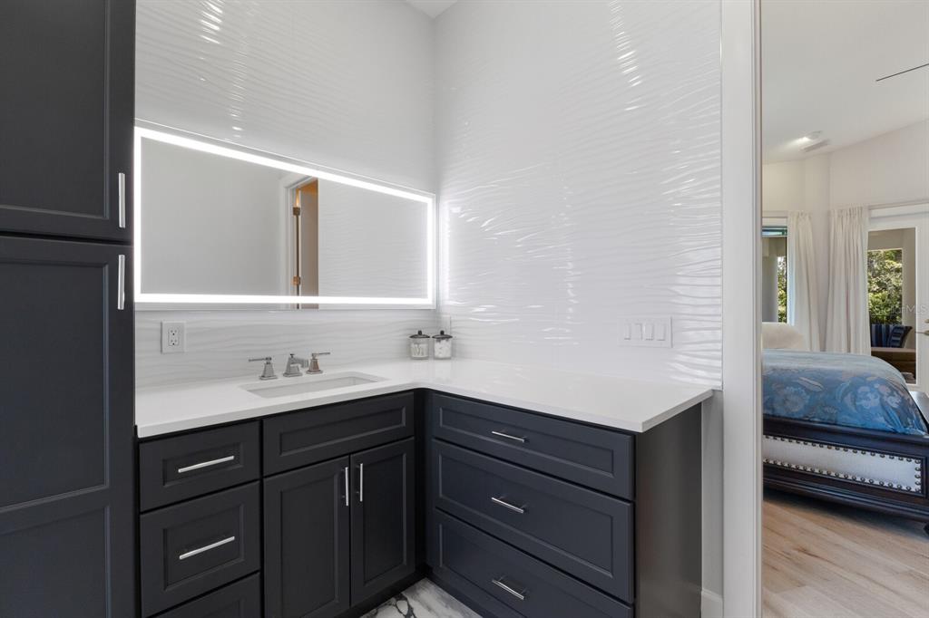 691 Eagle Watch Lane Osprey, FL 34229 - Photo 68 of 100 a en suite bathroom with a sink and a mirror