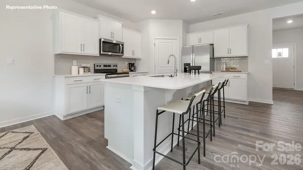 a kitchen with stainless steel appliances a microwave a stove a sink a stove a dining table and chairs