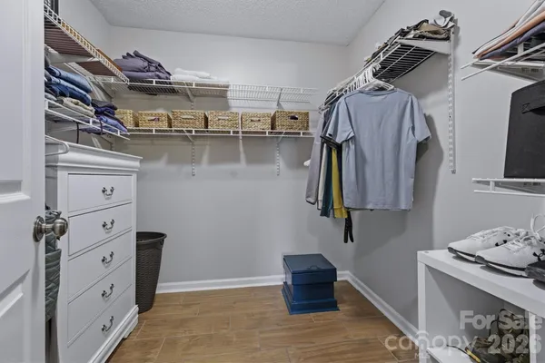 a view of walk in closet with clothes and shoes