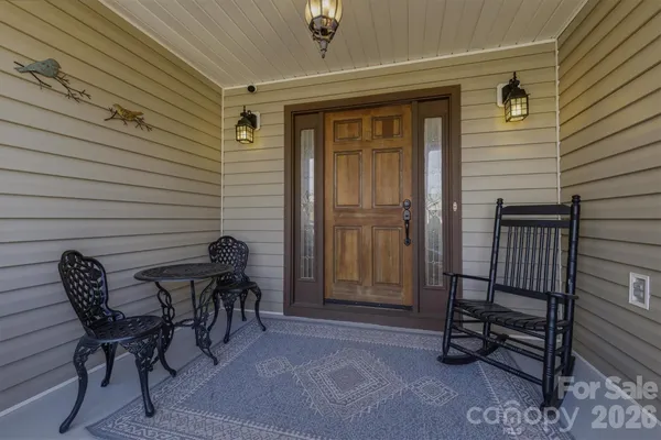 a view of a door with a chairs and bench in patio