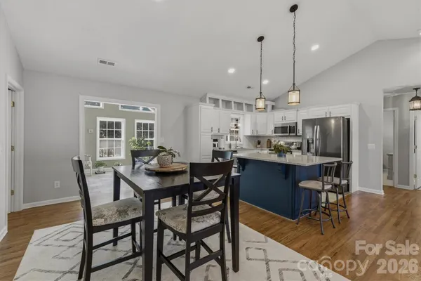 a view of a dining room and livingroom with furniture wooden floor a chandelier