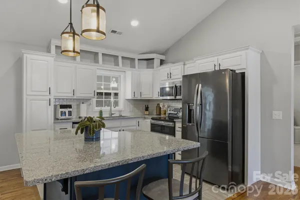 a kitchen with refrigerator and chairs