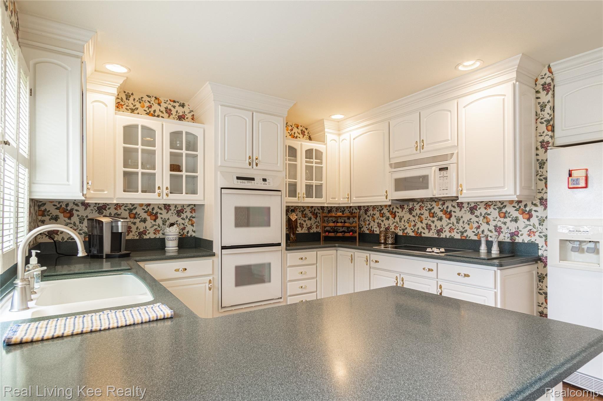 1329 Greenleaf Drive Rochester, MI 48309 - Photo 13 of 49 Kitchen features double sinks...lots of cabinets and counters for food preparation...side-by--side refrigerator with icemaker and water...custom touches include crown molding, indirect lighting, hardwood floors and more.
