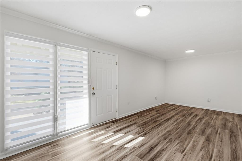 1150 Collier Road Northwest, Unit 24K Atlanta, GA 30318 - Photo 4 of 22 a view of empty room with wooden floor and fan