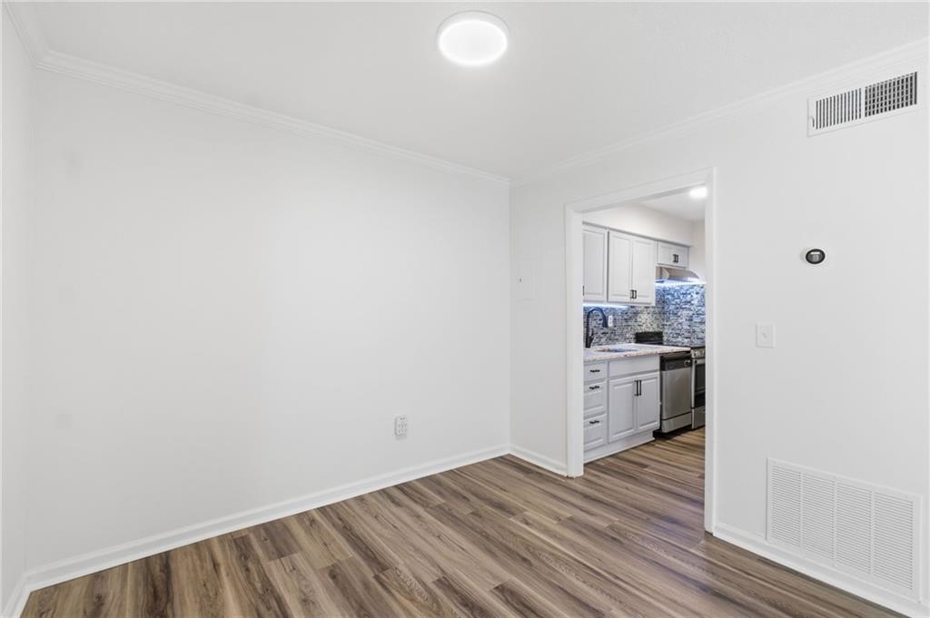 1150 Collier Road Northwest, Unit 24K Atlanta, GA 30318 - Photo 6 of 22 a view of a kitchen with a sink and dishwasher with wooden floor