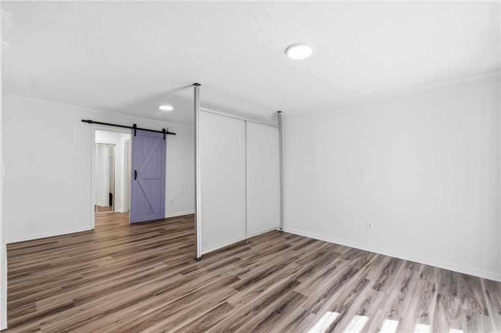 1150 Collier Road Northwest, Unit 24K Atlanta, GA 30318 - Photo 7 of 22 a view of an empty room with wooden floor