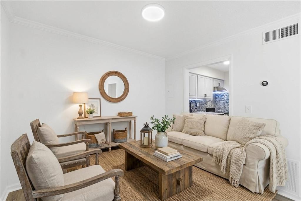 1150 Collier Road Northwest, Unit 24K Atlanta, GA 30318 - Photo 8 of 22 a living room with furniture a rug and a wall painting