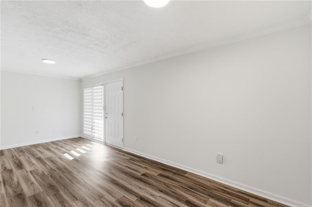 1150 Collier Road Northwest, Unit 24K Atlanta, GA 30318 - Photo 9 of 22 a view of empty room with wooden floor and fan