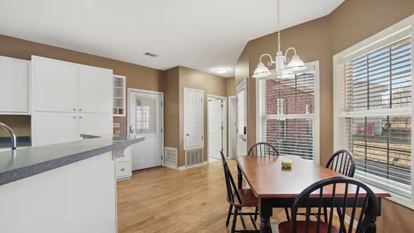 a view of a dining room with furniture a chandelier and wooden floor