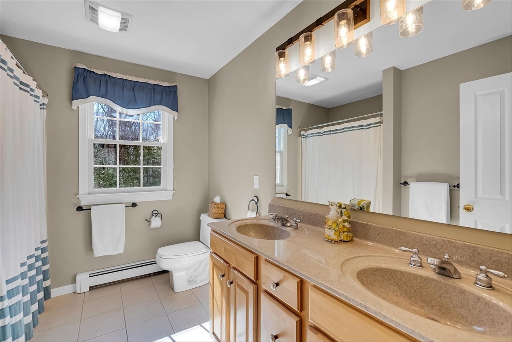 9 Juniper Road Upton, MA 01568 - Photo 25 of 42 a bathroom with a granite countertop sink mirror vanity bathtub and a toilet