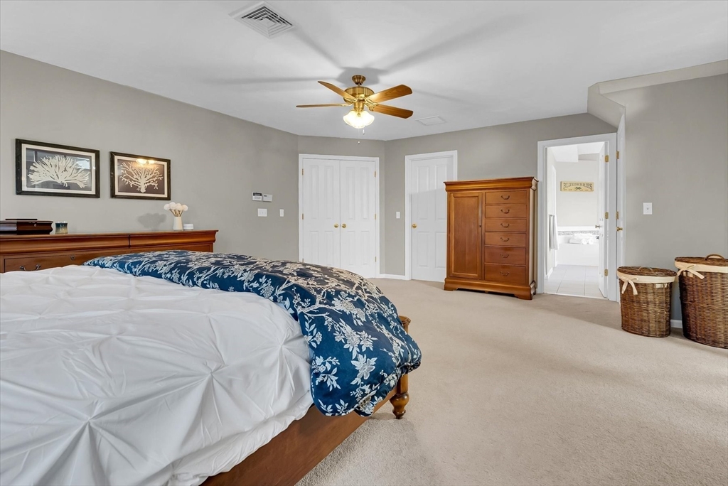 9 Juniper Road Upton, MA 01568 - Photo 28 of 42 a bedroom with a large bed and a chandelier