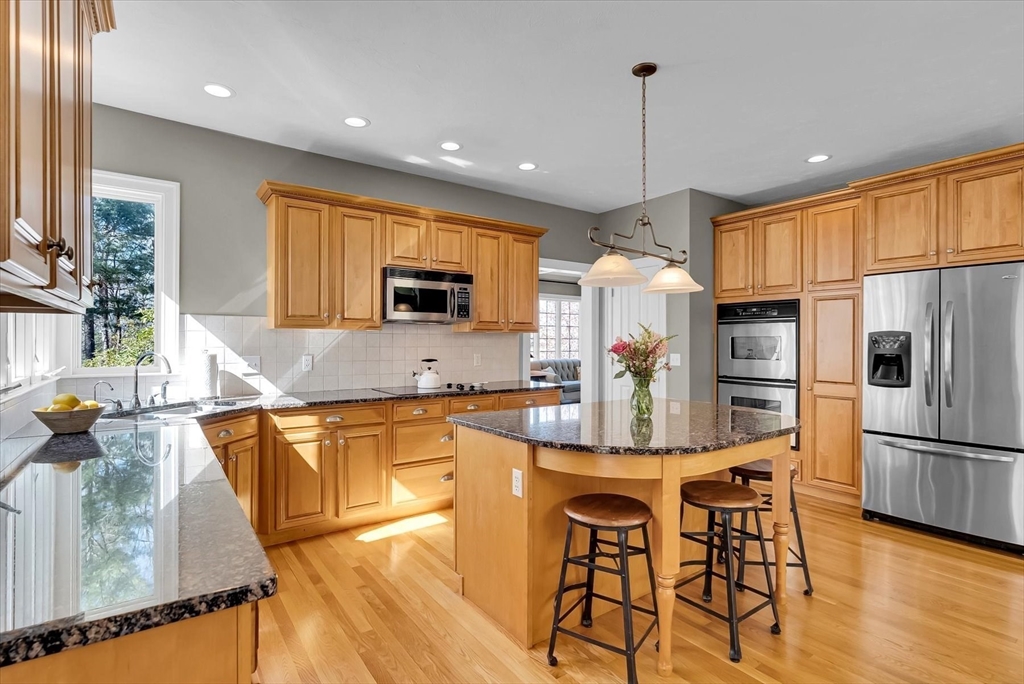 9 Juniper Road Upton, MA 01568 - Photo 10 of 42 a kitchen with granite countertop a refrigerator stove top oven dining table and chairs