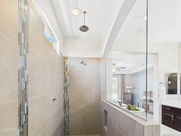 a bathroom with a sink and mirror with shower