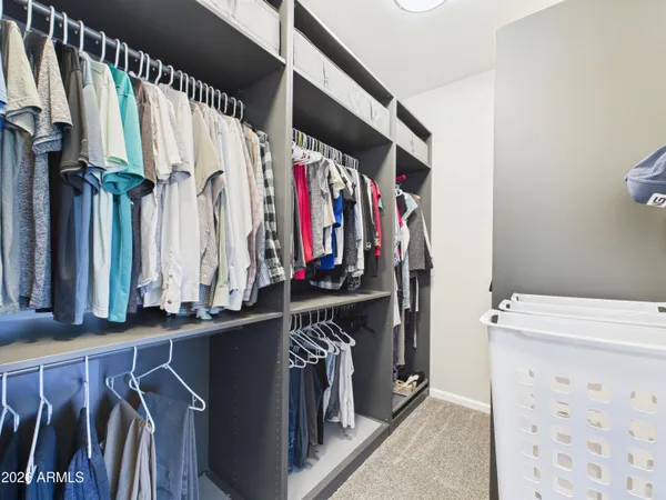 a view of walk in closet with clothes