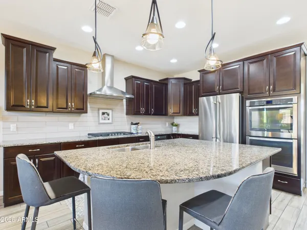 a kitchen with kitchen island granite countertop a table chairs microwave and cabinets