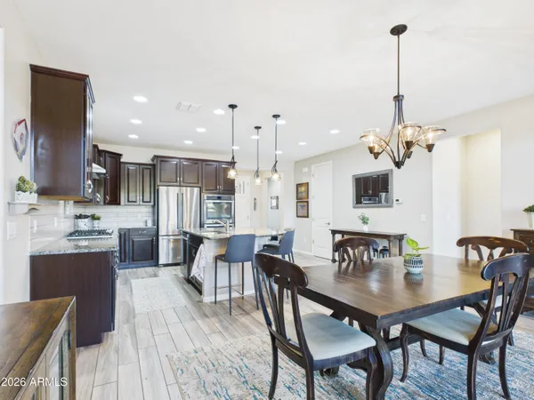 a view of a dining room and livingroom with furniture wooden floor a chandelier