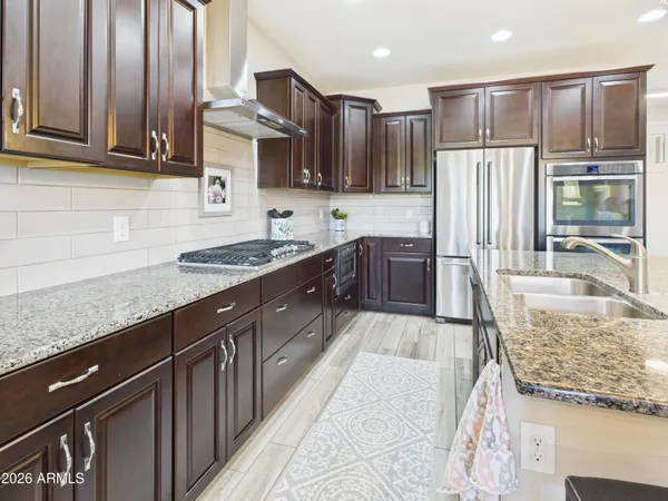 a kitchen with stainless steel appliances granite countertop a stove refrigerator and cabinets